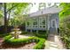 Backyard with a tiered fountain, well-maintained lawn, and a sunroom with many windows at 3030 Baltimore St, Charleston, SC 29492