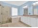 This primary bath features a glass enclosed shower, a tub under the window, and a double sink vanity at 3030 Baltimore St, Charleston, SC 29492