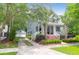 Charming two-story home with a welcoming front porch, lush trees, and driveway to a garage at 3030 Baltimore St, Charleston, SC 29492