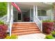 Welcoming porch with brick steps, white railings, columns, and patriotic American flag at 3030 Baltimore St, Charleston, SC 29492