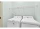 Bright laundry room with white washer and dryer, wire shelf, and pale green walls at 3030 Baltimore St, Charleston, SC 29492