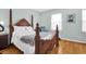 This main bedroom showcases a beautiful wood bed frame, hardwood floors, and natural light from the window at 3030 Baltimore St, Charleston, SC 29492