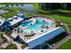 An inviting community pool with lush landscaping, umbrellas, seating, and a view of the pond at 310 Ripple Park Dr, Summerville, SC 29486