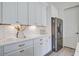 Modern kitchen features white cabinets, stainless steel refrigerator, and elegant gold hardware at 310 Ripple Park Dr, Summerville, SC 29486