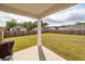 Covered patio looking out onto expansive, fenced backyard with lush, green grass and mature trees at 369 Spruce Ivy St, Moncks Corner, SC 29461