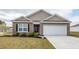 Well-maintained brick home featuring a two-car garage and tidy front yard at 369 Spruce Ivy St, Moncks Corner, SC 29461
