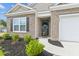 Welcoming front entrance with decorative plants, brick accents, and a charming storm door at 369 Spruce Ivy St, Moncks Corner, SC 29461