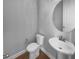 Elegant powder room featuring a pedestal sink, round mirror, toilet, and wood look flooring at 3700 Maidstone Dr, Mount Pleasant, SC 29466