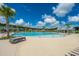 Expansive community pool with lounge chairs, palm trees, and clear blue water under a sunny sky at 4314 Cotton Flt Rd, Summerville, SC 29485