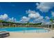 Beautiful community pool with sun loungers, palm trees, clear blue water, and great view under a sunny sky at 4314 Cotton Flt Rd, Summerville, SC 29485