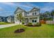Lovely two-story home boasts a landscaped lawn, a front porch, and an attached two-car garage at 4314 Cotton Flt Rd, Summerville, SC 29485