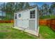 Shed with gray siding and white trim, offering extra storage space and a charming aesthetic in a fenced backyard at 4314 Cotton Flt Rd, Summerville, SC 29485