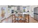 Modern kitchen with white cabinets, stainless steel appliances, island with seating, and access to backyard at 455 White Magnolia St, Moncks Corner, SC 29461