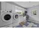 Well-lit kitchen with white cabinets, stainless appliances, and washer/dryer combo near a sunny window at 4971 Edge Ave, Charleston, SC 29405
