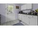 Charming kitchen featuring white cabinetry, a black countertop and direct access to the outdoors at 4971 Edge Ave, Charleston, SC 29405