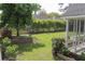 A lush backyard with manicured lawn, mature trees, and garden beds creates a private outdoor oasis at 518 Antebellum Ln, Mount Pleasant, SC 29464