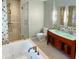 Modern bathroom featuring a soaking tub, glass shower, double sink vanity, and tile accents at 518 Antebellum Ln, Mount Pleasant, SC 29464