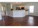 Open-concept living area with hardwood floors, decorative half-wall separating the kitchen, and plenty of light at 518 Antebellum Ln, Mount Pleasant, SC 29464