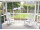 Inviting screened porch with two white rocking chairs overlooks a well-maintained backyard at 518 Antebellum Ln, Mount Pleasant, SC 29464