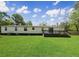 View of a large backyard with a wooden deck extending from the house at 570 Crystal Shores Dr, Moncks Corner, SC 29461