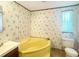 Retro-style bathroom with yellow bathtub, toilet, vintage wallpaper, and vanity at 570 Crystal Shores Dr, Moncks Corner, SC 29461