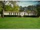 Well-maintained single-story home featuring a manicured lawn, mature trees, and a welcoming entrance at 570 Crystal Shores Dr, Moncks Corner, SC 29461
