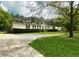 This single story home features a well-maintained lawn with mature trees with an extended driveway at 570 Crystal Shores Dr, Moncks Corner, SC 29461