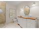 Well-lit bathroom featuring a glass shower, single sink, and window with plantation shutters at 66 New Settlement Rd, Kiawah Island, SC 29455