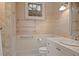 Bright bathroom featuring a travertine tiled wall, white vanity, and natural light from a window at 66 New Settlement Rd, Kiawah Island, SC 29455