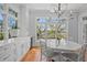 Bright dining area with white table and chairs, built-in cabinets, and a large window with a view at 66 New Settlement Rd, Kiawah Island, SC 29455