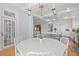 Bright dining room with a view of the kitchen, featuring a white table and chandelier at 66 New Settlement Rd, Kiawah Island, SC 29455