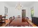 Bright dining room with a long wooden table, seating for eight, chandelier, and hardwood floors at 66 New Settlement Rd, Kiawah Island, SC 29455