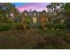 Inviting two-story home with a well-lit porch and landscaped front yard under a vibrant sunset sky at 66 New Settlement Rd, Kiawah Island, SC 29455