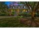 Twilight view of a charming two-story home with a manicured front lawn and symmetrical landscaping at 66 New Settlement Rd, Kiawah Island, SC 29455