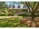 Charming two-story home with a manicured front lawn, symmetrical landscaping, and a welcoming front porch at 66 New Settlement Rd, Kiawah Island, SC 29455
