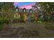 Twilight view of a charming two-story home with a manicured front lawn and symmetrical landscaping at 66 New Settlement Rd, Kiawah Island, SC 29455