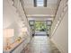 Foyer with beautiful stone flooring and double staircase leading to open front doors and a view of the yard at 66 New Settlement Rd, Kiawah Island, SC 29455