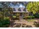 Charming front exterior of home with a cozy porch, manicured lawn, and lush, mature trees at 66 New Settlement Rd, Kiawah Island, SC 29455