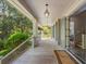 Long covered porch with gray columns, hanging lanterns, and a view of the landscaped front yard at 66 New Settlement Rd, Kiawah Island, SC 29455