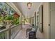 Inviting covered porch with hanging plants, wicker chair, and tranquil outdoor views at 66 New Settlement Rd, Kiawah Island, SC 29455