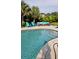 Inviting backyard pool with comfortable seating area, palms, and lush tropical landscaping at 711 Farm Cottage Ln, Charleston, SC 29412