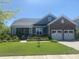 Charming two-story home featuring a brick and siding facade, well-manicured lawn, and attached two car garage at 711 Farm Cottage Ln, Charleston, SC 29412