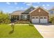 Inviting exterior view of a home with a well-manicured lawn, a two-car garage, and a cozy front porch at 711 Farm Cottage Ln, Charleston, SC 29412