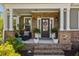 Charming front porch adorned with brickwork, columns, and potted plants, creating an inviting entrance at 711 Farm Cottage Ln, Charleston, SC 29412