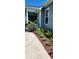 Landscaped side yard features colorful flowerbeds, mulch, and a view of the covered porch and home's siding at 711 Farm Cottage Ln, Charleston, SC 29412