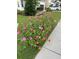Well-maintained front yard with a colorful flowerbed and lush green lawn at 711 Farm Cottage Ln, Charleston, SC 29412