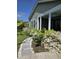 Charming home exterior with stone path, lush plantings, and white flowering bushes at 711 Farm Cottage Ln, Charleston, SC 29412