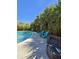 Refreshing pool area with tropical landscaping, outdoor seating and sunny skies at 711 Farm Cottage Ln, Charleston, SC 29412