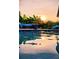 Stunning sunset view over a sparkling pool, with comfortable seating and lush tropical foliage creating a serene retreat at 711 Farm Cottage Ln, Charleston, SC 29412
