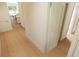 Interior hallway showcasing light wood floors, white trim, and doorways leading to the bathroom and living areas at 7425 Indigo Palms Way, Johns Island, SC 29455